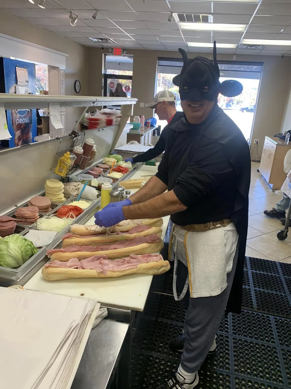 A member of Pete's counter staff preparing subs